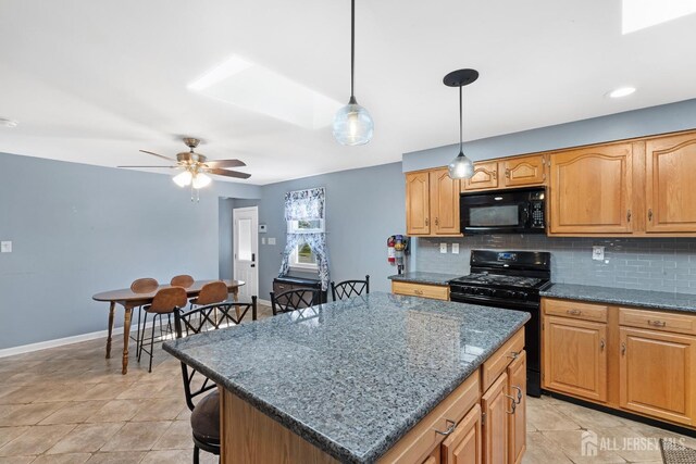 kitchen with pendant lighting, dark stone counters, tasteful backsplash, and black appliances