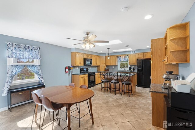 dining space with recessed lighting, ceiling fan, and a skylight