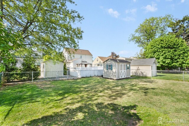 view of yard featuring a storage shed, an outbuilding, and a fenced backyard