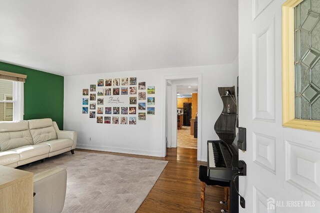 living area with baseboards and wood finished floors