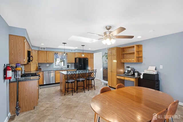 kitchen featuring a sink, black refrigerator with ice dispenser, tasteful backsplash, stainless steel dishwasher, and a kitchen island