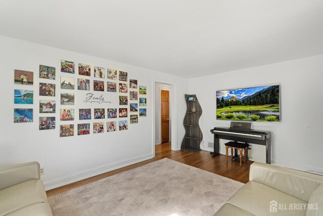 living area featuring baseboards and wood finished floors