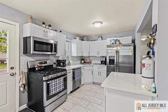 60 Sycamore St, Carteret, NJ 07008 - kitchen featuring appliances with stainless steel finishes, tasteful backsplash, white cabinets, and light stone countertops
