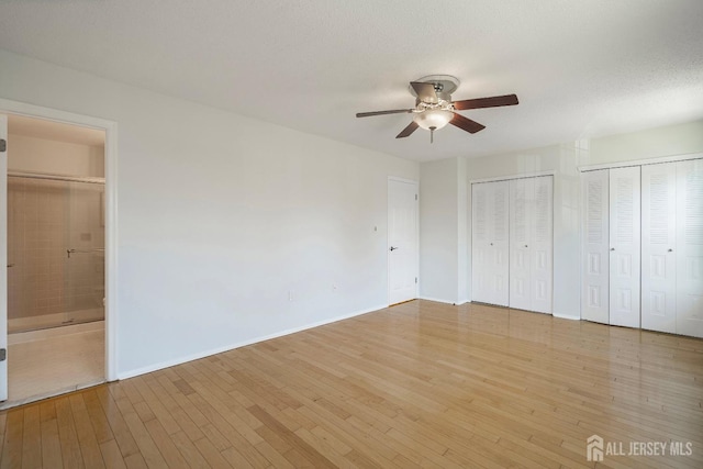 18 Albury Way N, Brunswick, NJ 08902 - unfurnished bedroom featuring light wood finished floors, two closets, ensuite bathroom, baseboards, and ceiling fan