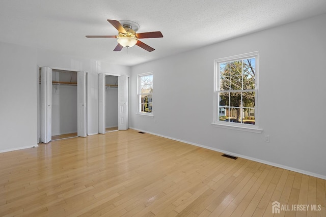 18 Albury Way N, Brunswick, NJ 08902 - unfurnished bedroom featuring multiple closets, baseboards, and light wood-style flooring