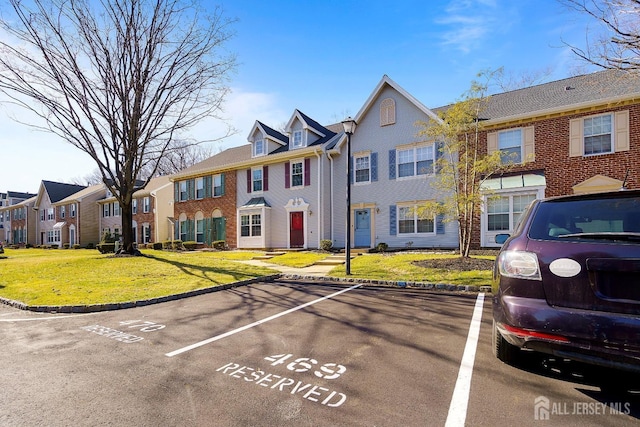 18 Albury Way N, Brunswick, NJ 08902 - view of property with a residential view, uncovered parking, a front yard, and brick siding