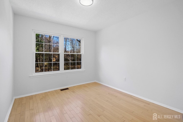 18 Albury Way N, Brunswick, NJ 08902 - spare room featuring light wood-style floors, a textured ceiling, and baseboards