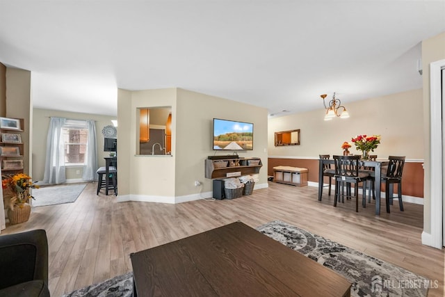 living room with a notable chandelier and light hardwood / wood-style flooring