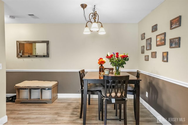 dining room featuring a chandelier and light hardwood / wood-style flooring