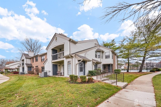 view of front of home featuring central AC unit and a front yard