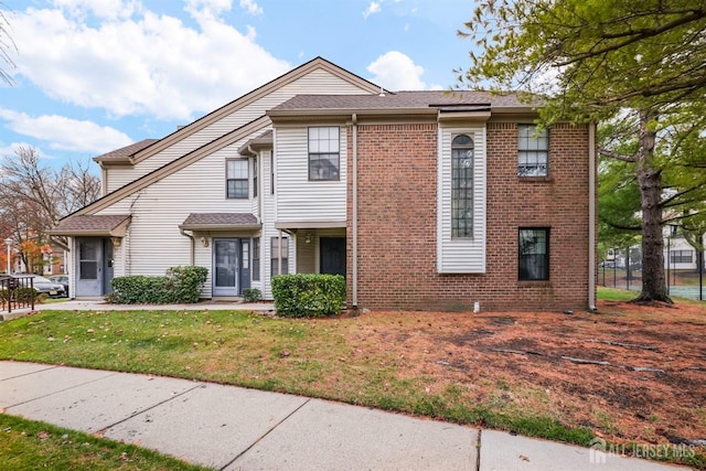 view of front of home featuring brick siding and a front yard