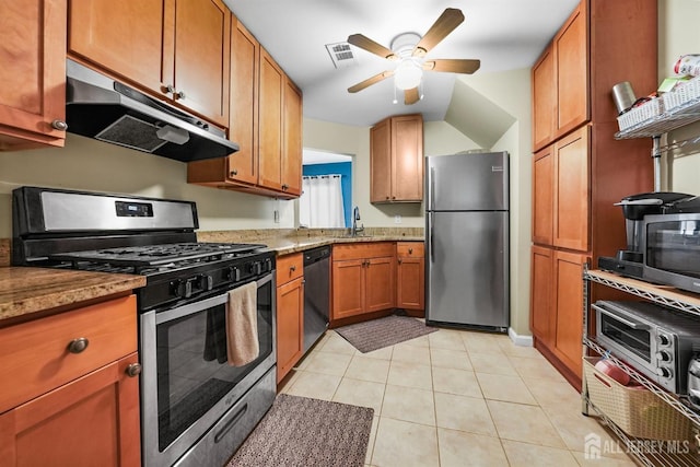 kitchen featuring appliances with stainless steel finishes, sink, light tile patterned floors, ceiling fan, and light stone countertops