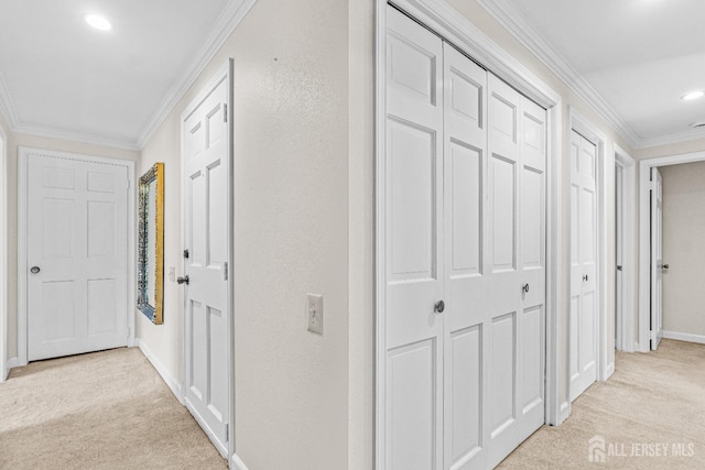 corridor with baseboards, recessed lighting, crown molding, and light colored carpet