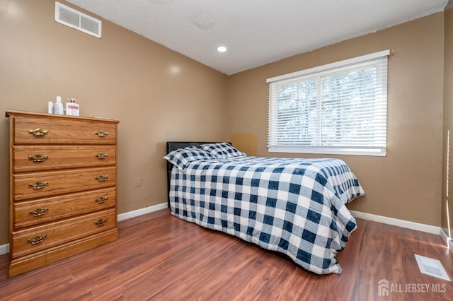 bedroom with recessed lighting, dark wood finished floors, visible vents, and baseboards