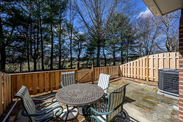 deck featuring a patio area, a fenced backyard, outdoor dining space, and central AC