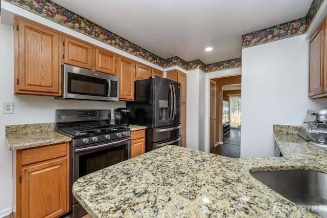 kitchen featuring light stone counters, stainless steel appliances, and recessed lighting