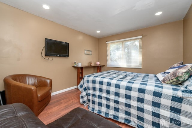 bedroom with recessed lighting, wood finished floors, and baseboards