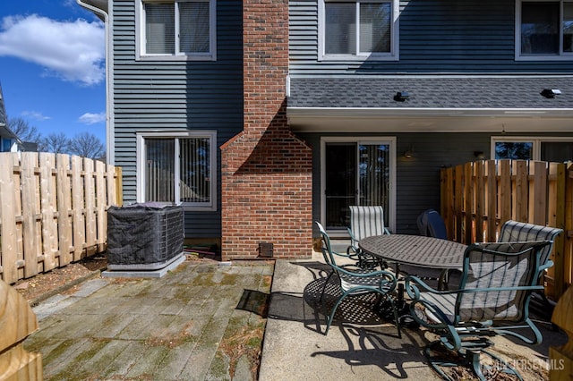 view of patio / terrace featuring a fenced backyard, central AC, and outdoor dining space