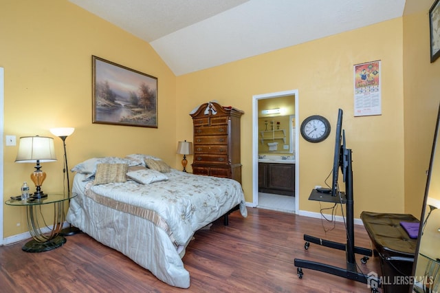 bedroom featuring ensuite bath, lofted ceiling, wood finished floors, and baseboards
