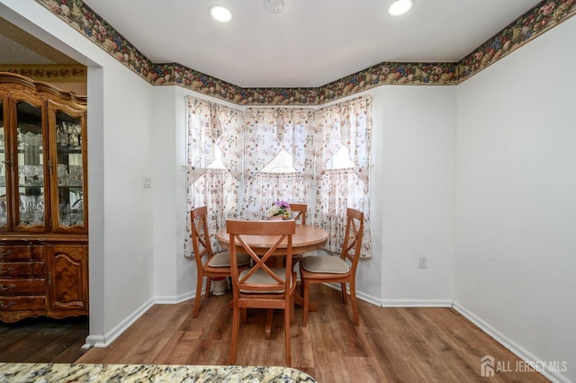 dining room featuring baseboards, wood finished floors, and recessed lighting
