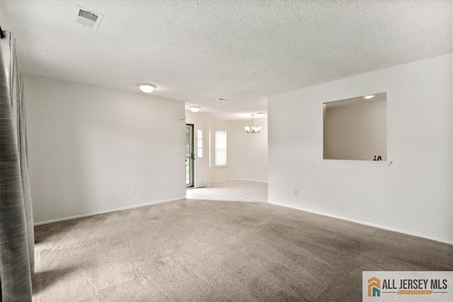 1601 Pebble Pl Unit 1601, Sayreville, NJ 08859 - carpeted spare room featuring an inviting chandelier, a textured ceiling, and visible vents