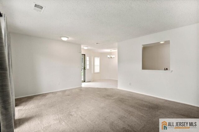 1601 Pebble Pl Unit 1601, Sayreville, NJ 08859 - spare room with a chandelier, carpet, and a textured ceiling