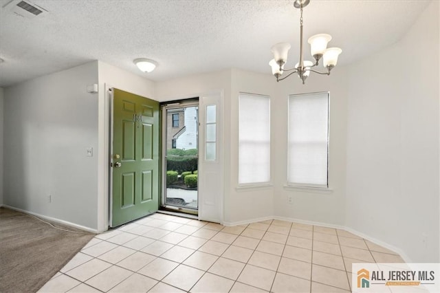 1601 Pebble Pl Unit 1601, Sayreville, NJ 08859 - entrance foyer featuring light tile patterned flooring, a textured ceiling, a notable chandelier, and visible vents