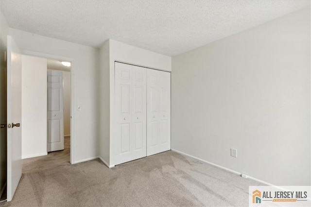 1601 Pebble Pl Unit 1601, Sayreville, NJ 08859 - unfurnished bedroom featuring baseboards, carpet flooring, a textured ceiling, and a closet