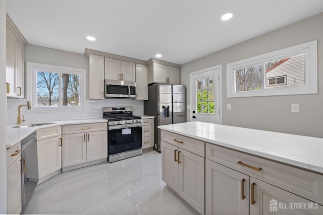 273 Park St, Franklin Twsp, NJ 08873 - kitchen featuring stainless steel appliances, a sink, backsplash, light countertops, and recessed lighting