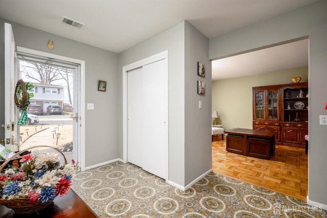 entryway featuring baseboards and visible vents