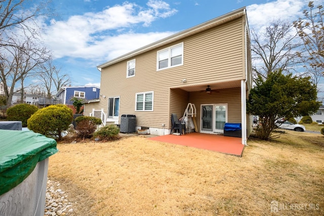 rear view of property featuring a lawn, central AC, ceiling fan, and a patio area