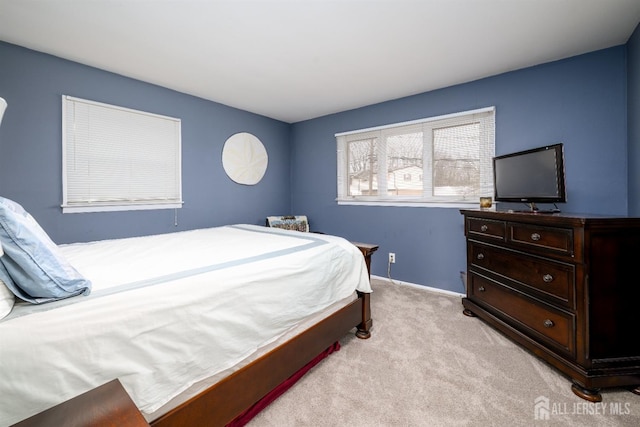 bedroom with baseboards and light colored carpet