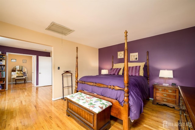 bedroom with light wood-style floors, visible vents, and baseboards