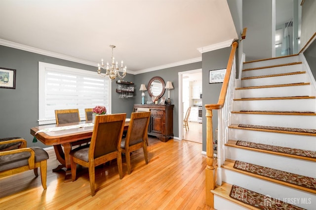 dining room with baseboards, ornamental molding, stairs, light wood-type flooring, and a chandelier