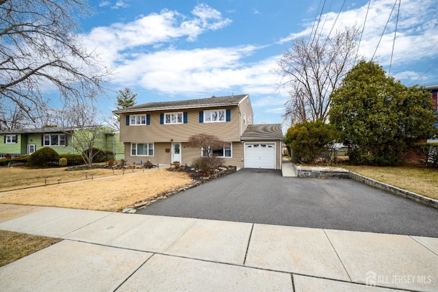 view of front facade with aphalt driveway and an attached garage