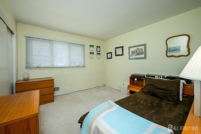 carpeted bedroom featuring a closet and visible vents