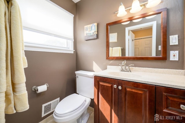 half bathroom with vanity, toilet, and visible vents