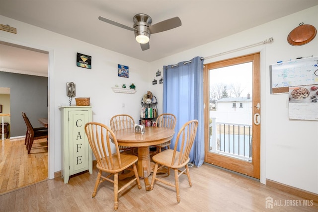 dining room with light wood-style flooring, baseboards, and ceiling fan