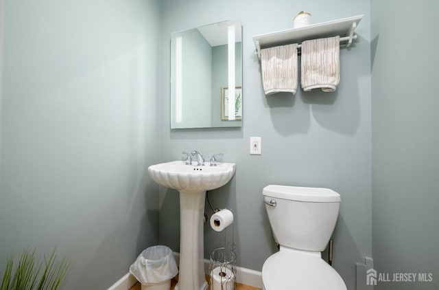 bathroom featuring toilet and baseboards