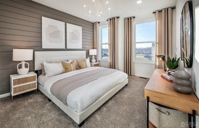 carpeted bedroom with wood walls and a chandelier