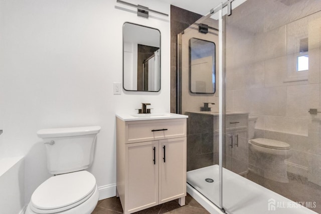 bathroom featuring a stall shower, baseboards, toilet, tile patterned floors, and vanity