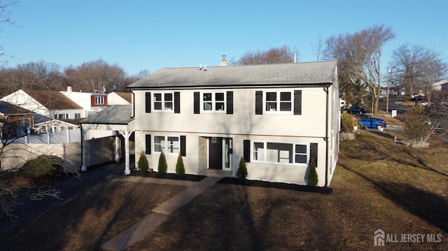 colonial-style house with driveway and fence