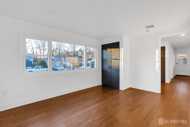 empty room with baseboards and wood finished floors