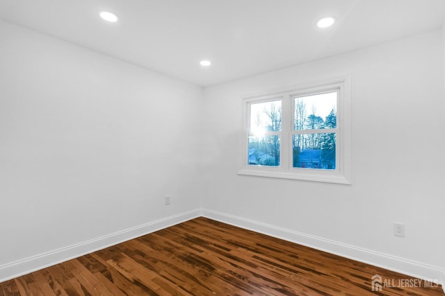 unfurnished room featuring recessed lighting, dark wood finished floors, and baseboards