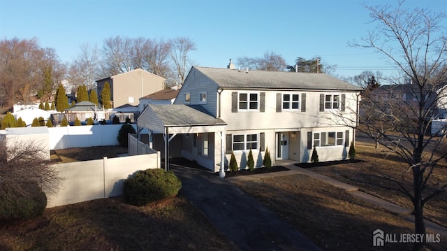 colonial house with driveway and fence