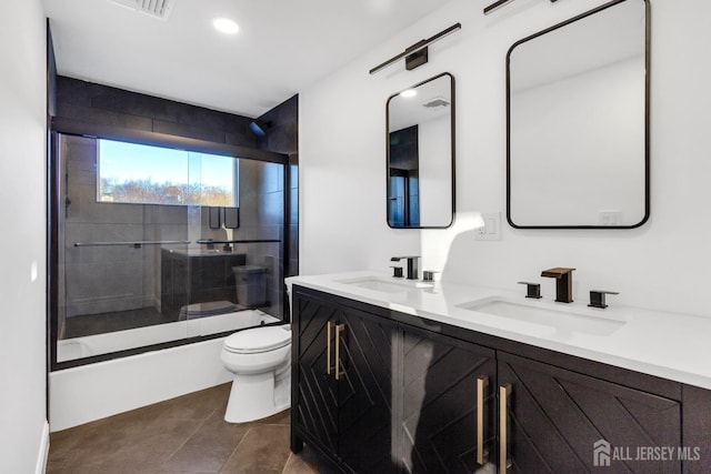 bathroom with double vanity, tile patterned flooring, a sink, and toilet