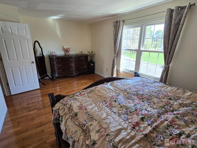 bedroom featuring baseboards and wood finished floors