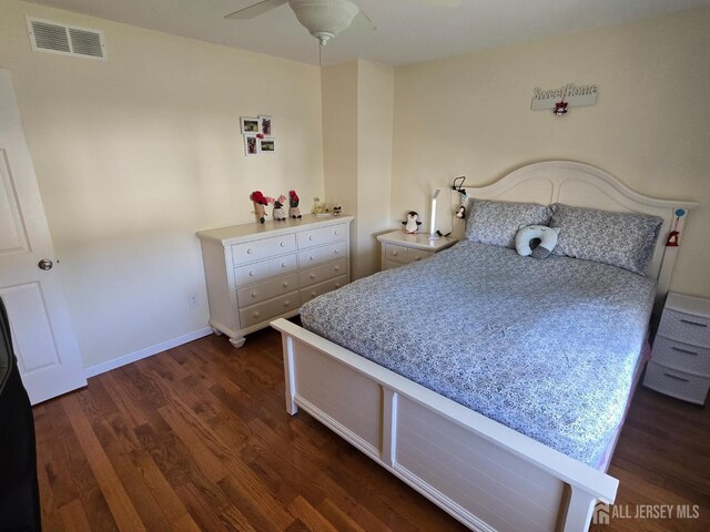 bedroom with baseboards, dark wood finished floors, and visible vents