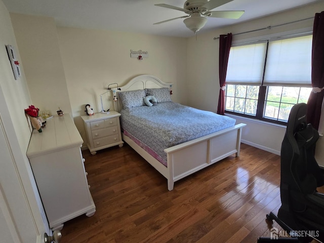 bedroom featuring baseboards, dark wood finished floors, and ceiling fan