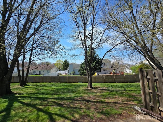 view of yard with a fenced backyard and a residential view